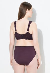 Donkerpaarse lingerie set met kantdetails op de beha, verstelbare bandjes en hooggewaist onderbroeken met een soepele textuur.