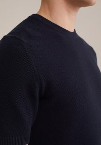 Dark navy short-sleeve knit sweater with textured fabric and a crew neckline, featuring subtle ribbed detailing on sleeves and hem.