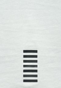 Fehér póló, amelynek bal oldalán hét fekete, téglalap alakú csík függőleges elrendezésben helyezkedik el, puha pamut szövetből készült.