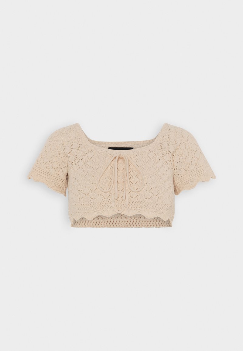 Beige crop toppi, jossa on neliskulmainen pääntie, lyhyet aaltoilevat hihat, neulottu tekstuuri ja etutaittotyyny. Aaltoileva helma vyötäröllä.