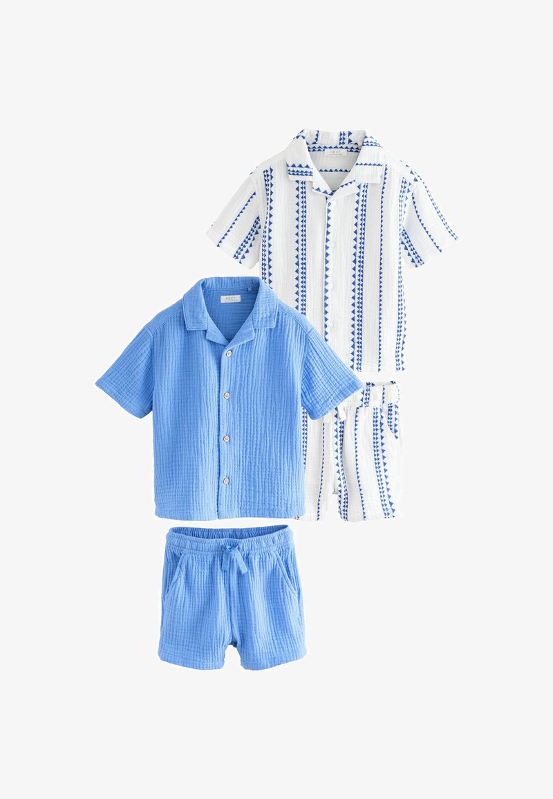 Deux ensembles chemise à manches courtes boutonnés et shorts pour enfants, un uni bleu clair et l’autre blanc avec des rayures géométriques bleues.