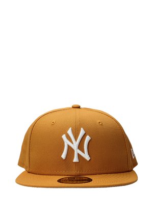 Cappello da baseball marrone con visiera piatta, logo NY intrecciato bianco ricamato sul davanti e piccoli fori di ventilazione cuciti sui pannelli superiori.
