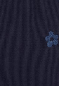 Navy ribbed fabric with a textured surface, featuring a blue embroidered flower motif on the lower right corner.
