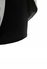 Pantalones cortos deportivos negros con una textura suave, combinados con una superposición de tela gris jaspeada, mostrando un diseño en capas.