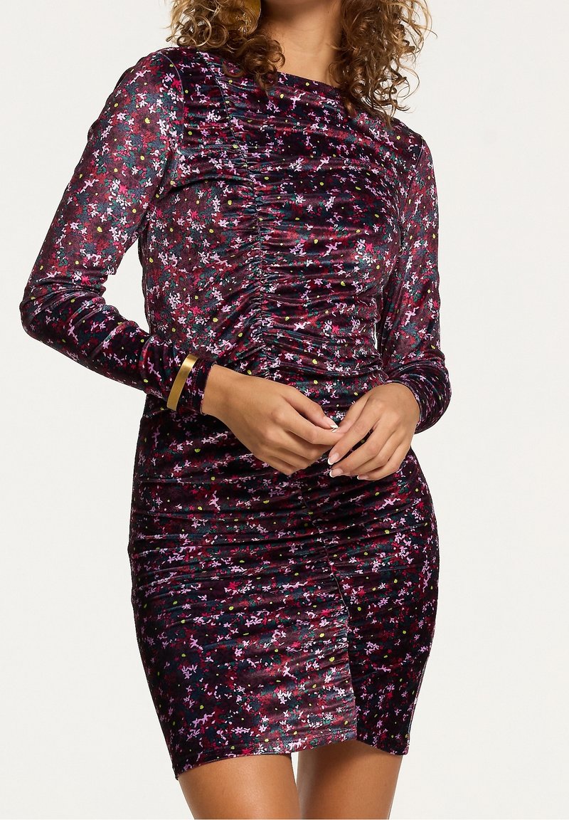 Robe en velours à manches longues, design froncé de couleur violet foncé avec des motifs floraux multicolores et des pois, style ajusté avec une longueur mini.