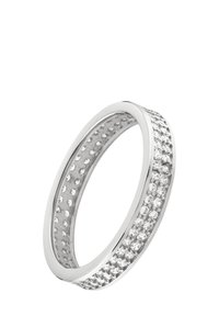 Bague en argent avec une bande lisse ornée d'une rangée de petites pierres claires sur un côté et un intérieur texturé avec des découpes circulaires.