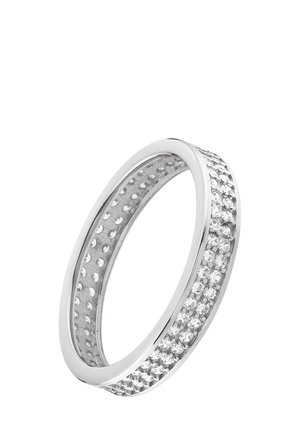 Bague en argent avec une bande lisse ornée d'une rangée de petites pierres claires sur un côté et un intérieur texturé avec des découpes circulaires.