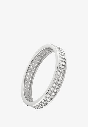 Bague en argent avec une bande lisse ornée d'une rangée de petites pierres claires sur un côté et un intérieur texturé avec des découpes circulaires.