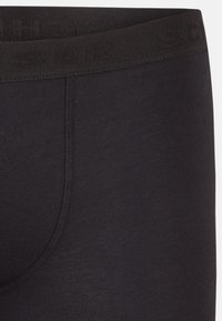 Boxer briefs neri in cotone con un cinturino elastico testurizzato che presenta il nome del marchio in un motivo in rilievo discreto. Leggermente elasticizzati, con una superficie liscia.