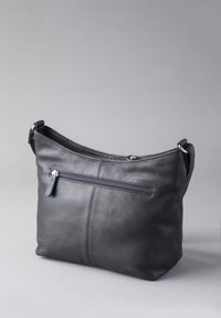 Black leather shoulder bag with a smooth texture, curved top, and a zippered back pocket. Features a detachable strap and minimalistic design.
