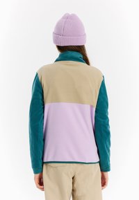 Fleecejack met een kleurblokontwerp in teal, beige en lavendel, met een hoge kraag en lange mouwen. Gehaakte paarse beanie.