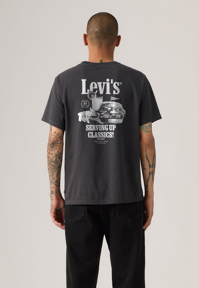 T-shirt en coton gris avec un imprimé graphique au dos comprenant du texte et des images liées à la nourriture, manches courtes et coupe décontractée.