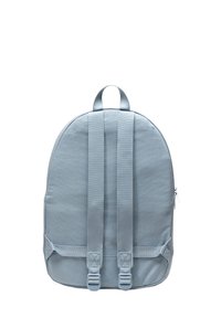 Sac à dos bleu clair en tissu, avec une forme ronde, des bretelles matelassées, une anse supérieure et une poche zippée sur le côté.