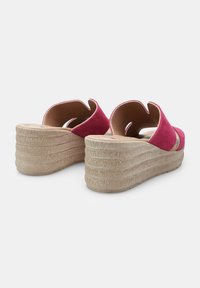 Sandales à talon compensé en daim rose avec design découpé, plateforme beige texturée et bords courbés, dotées d'une doublure intérieure douce et lisse.