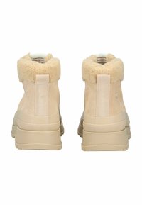 Beige suède enk boots met een fluffy crèmekleurige kraag, elastische zijpaneel en gemoleculiseerde rubberen zool. afgeronde hak voor stabiliteit.