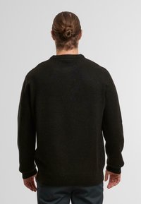 Dunkelgrüner Strickpullover mit rundem Halsausschnitt, gerippten Bündchen und Saum. Der Stoff wirkt weich mit einer dicken, warmen Textur. Rückansicht gezeigt.