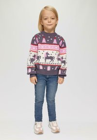 Kolorowy sweter dzianinowy z świątecznym wzorem przedstawiającym jednorożce, drzewa i pudełka prezentowe. Ciemnofioletowa baza z różowymi i białymi akcentami.