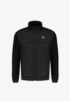 Veste zippée noire avec panneaux avant matelassés, manches en tissu doux, col montant et un petit logo sur la poitrine.