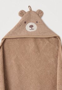 Καφέ πετσέτα με κουκούλα από μαλακό περκάλι. Διαθέτει πρόσωπο αρκούδας με κεντημένα μάτια και μύτη, καθώς και αυτιά στην κορυφή της κουκούλας.