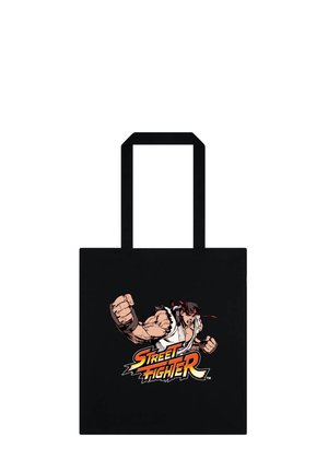 Czarna torba typu tote z wizerunkiem muskularnego wojownika w białym gi i czerwonej opasce na głowie, który uderza pięścią do przodu nad logo „Street Fighter”.