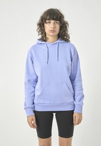 Hellblaues Hoodie aus weichem Baumwollmaterial, mit einer Fronttasche, verstellbarem Kordelzug und gerippten Bündchen, getragen mit schwarzen Shorts.