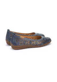 Bailarinas de cuero perforado azul con cortes florales, diseño de punta de almendra, suela de goma marrón y plantilla color beige. Costuras notables y etiqueta de marca.