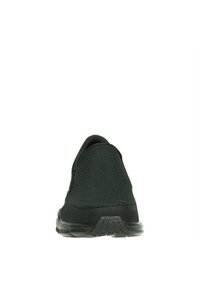 Svart sportskor sedd bakifrån, som visar ett texturerat tygöverdrag och en gummisula, vilket framhäver en elegant, modern design.