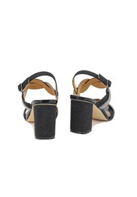 Sandali neri con tacco a blocco, dotati di cinturini testurizzati, finitura lucida e un tacco glitterato. Presentano un cinturino alla caviglia regolabile per una vestibilità perfetta.