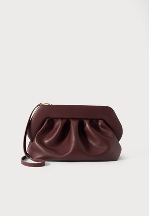 Pochette en cuir marron foncé avec un design froncé, une structure de cadre supérieure et une fine bandoulière en cuir pour poignet sur fond uni.