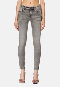 Úzké džíny v bledě šedém denimu, se středním pasem, designem pěti kapes a jemným detailním efekt hlazení. Stylizováno s páskovými podpatky.