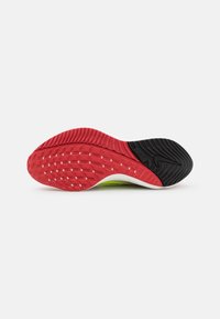 Semelle extérieure en caoutchouc rouge et noir avec un motif texturé. Présente une forme incurvée et un contraste de couleurs vibrantes. Convient aux chaussures de sport.