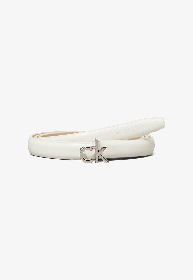 Ceinture fine en cuir blanc enroulée avec une boucle en métal argenté en forme des lettres minuscules c et k.