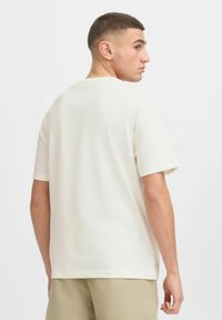Kortærmet t-shirt med rund hals i off-white, let stof med en blød tekstur, har en afslappet pasform og enkelt design.