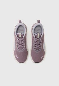 Lilla tekstilsneakers med mesh-overdel, myk polstret krage og flate lisser. Har en fremtredende logo på tungen og kontrasterende såle.