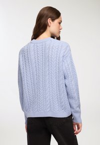Jasnoniebieski sweter z dzianiny w splot kablowy z prążkowanymi mankietami i dołem. Posiada pionowe wzory kablowe oraz okrągły dekolt. Pokazano widok z tyłu.