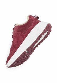Sneaker en suede bordeaux avec une semelle blanche texturée, mise en valeur par un intérieur en crème doux et un détail de logo sur le côté. Semelle en caoutchouc pour une meilleure adhérence.