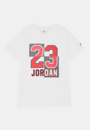 T-shirt blanc avec un grand numéro rouge "23" et le mot "JORDAN" en lettres majuscules au centre devant.