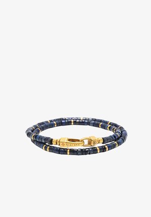 Perlearmbånd med mørkeblå og guldfarvede accenter, med små firkantede perler og en guldlås markeret "NIALAYA."