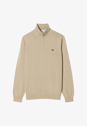 Maglione beige con mezza cerniera, polsini e orlo a coste, con un piccolo logo verde sul petto. Tessuto lavorato a maglia liscio.