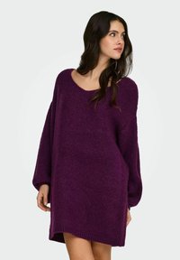 Fioletowa, oversize'owa sukienka sweterkowa z szerokim dekoltem i długimi rękawami, charakteryzująca się miękką fakturą i prążkowanym obwodem.