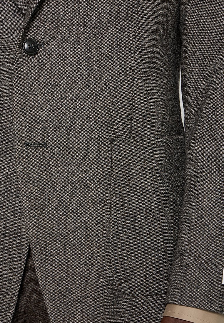 Brauner Herringbone-Blazer mit Reverskragen, einem knopflichen Verschluss und einer Seitentasche mit glatter Stoffauskleidung.