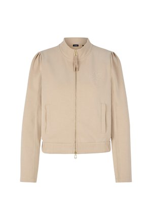 Veste beige zippée avec des manches bouffantes, des poignets côtelés et un ourlet côtelé. Elle présente un logo brodé sur la poitrine et deux poches avant. Tissu doux.