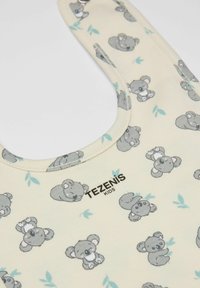 Dětská bryndák vyrobený ze světle žluté látky s jemnou strukturou, zdobený šedými ilustracemi koal a zelenými listy. Logo "TEZENIS KIDS".
