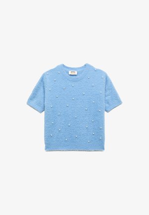Suéter de manga corta azul claro hecho de material esponjoso, decorado con acentos parecidos a perlas blancas distribuidos uniformemente por el frente. Escote redondo.