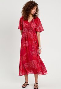 Abito maxi rosso floreale con maniche a soffietto corte, scollatura a v e tessuto strutturato, caratterizzato da una silhouette fluente e un design a motivo.