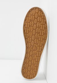 Gum sole with a textured pattern, light tan color, and contrasting white edge. Size labeled as 37. Flat and round toe design.