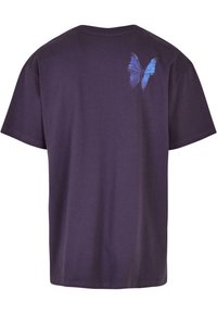 Purple cotton t-shirt with short sleeves, featuring a blue butterfly graphic on the upper back. Soft texture, relaxed fit.