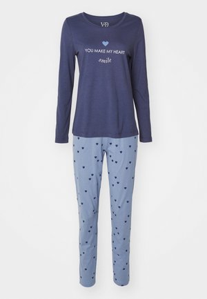Laivastonsininen pitkähiha pyjamapaita, jossa on valkoista tekstiä ja sydämellinen grafiikka; vaaleansiniset pyjamahousut, joissa on satunnaisia tummansinisia sydämiä.