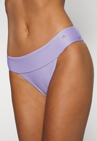 Fundo de bikini roxo com textura canelada, apresentando uma cintura larga e um corte baixo, destacando uma superfície suave e um design simples.