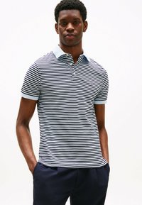 Marineblå og hvide stribede polo t-shirt med korte ærmer, en lyseblå krave og tre-knap lukning; prydet med logo på brystet.